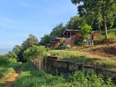 Wooden cottages on a green hillside by the Godavari in the Papikondalu hills