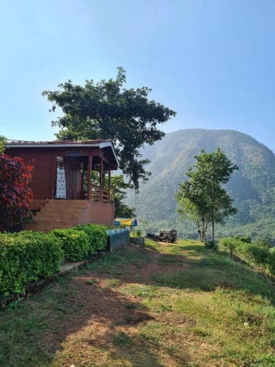 Wooden cottage in the Papikondalu hills with a hill behind it
