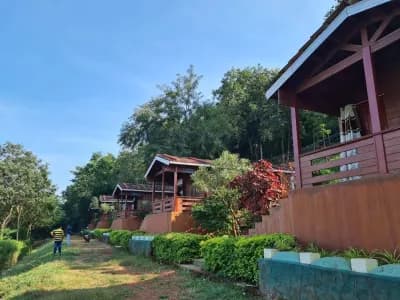 Row of wooden cottages along a garden path in the Papikondalu hills