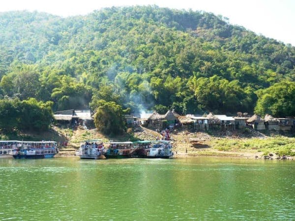 Tourist boats moored at the Gandipochamma temple ghat below forested hills on the Godavari